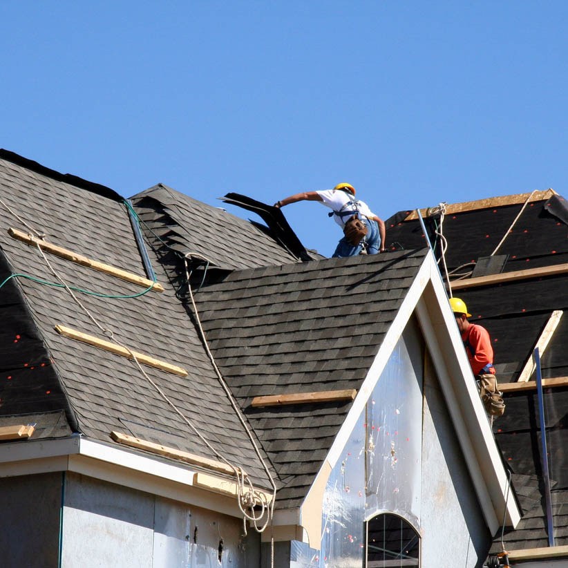 Roof Workers on top of house with blue sky